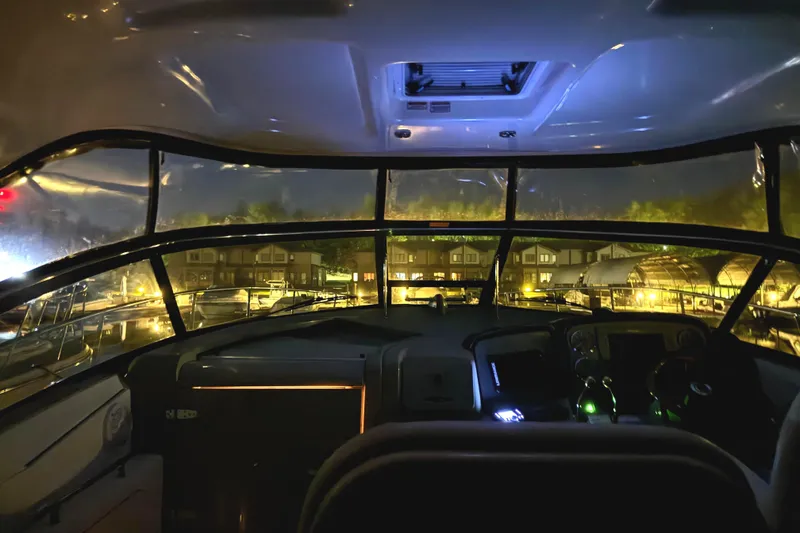 Slide: The Image of Interior view of 2006 Sea Ray 38 Sundancer yacht at night, docked with illuminated dashboard. - 14