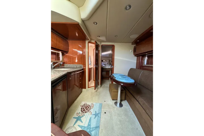 Slide: The Image of 2006 Sea Ray 38 Sundancer interior with kitchen, seating area, and nautical decor. - 16