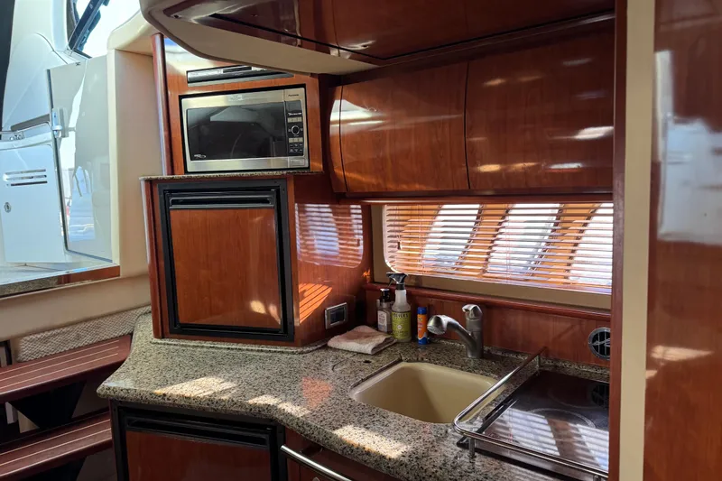 Slide: The Image of Luxurious 2006 Sea Ray 38 Sundancer yacht kitchen with wood cabinetry and granite countertops. - 18