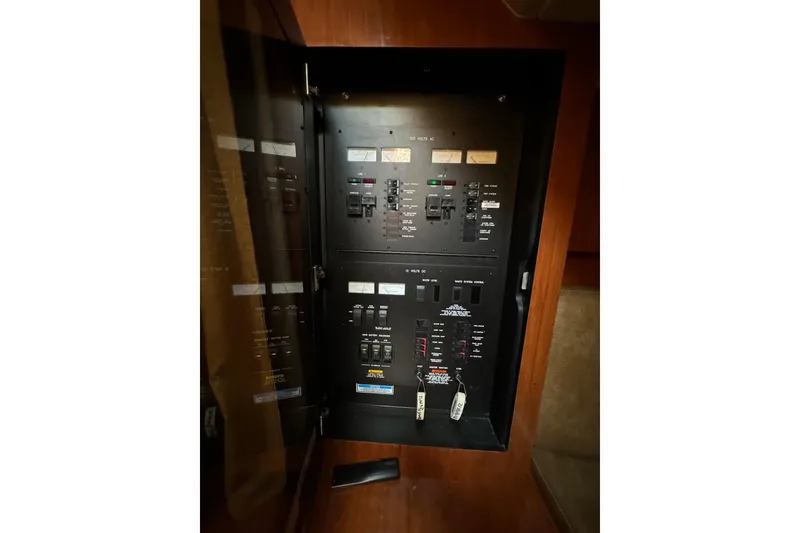 Slide: The Image of Electrical panel inside 2006 Sea Ray 38 Sundancer yacht, showcasing circuit breakers and controls. - 27