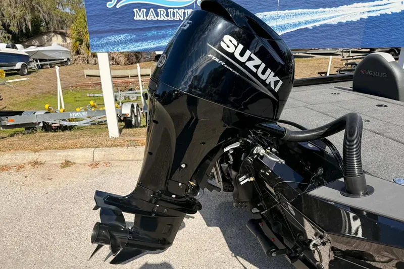 Slide: The Image of 2026 Vexus Defender 181 boat with Suzuki outboard motor in a marina setting. - 12