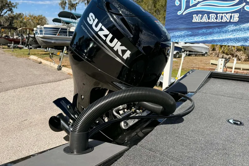 Slide: The Image of 2026 Vexus Defender 181 boat with Suzuki outboard motor at a marine dealership. - 13