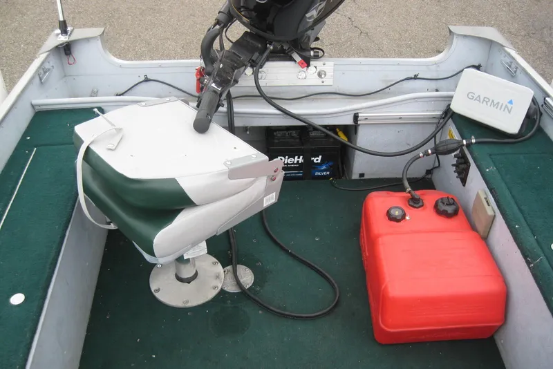 Slide: The Image of 1999 Lund 1440-V Rebel Tiller boat interior with Garmin device and fuel tank. - 10