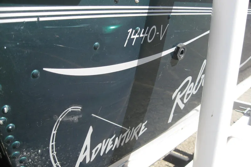 Slide: The Image of 1999 Lund 1440-V Rebel Tiller boat with "Adventure" decal on the side. - 4