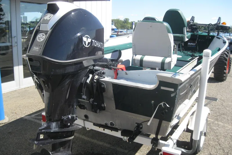 Slide: The Image of 1999 Lund 1440-V Rebel Tiller boat with Tohatsu outboard motor on trailer. - 5