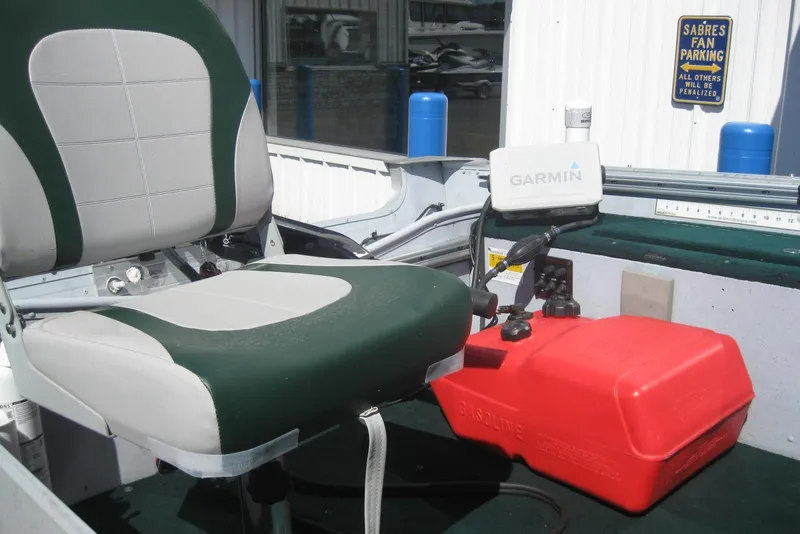 Slide: The Image of 1999 Lund 1440-V Rebel Tiller boat interior with seat, Garmin device, and red fuel tank. - 8