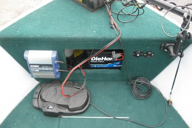 Slide: The Image of 1999 Lund 1440-V Rebel Tiller boat interior with battery and charger setup. - 9