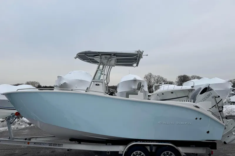 The Image of 2026 Cape Horn 22 OS boat on trailer, side view, in a snowy marina. - 0