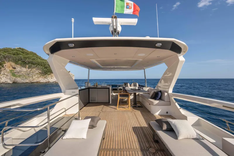 Slide: The Image of Luxurious 2026 Absolute Navetta 58 yacht deck with elegant seating, ocean view, and Italian flag. - 26