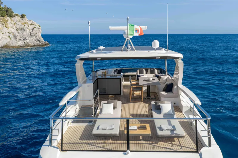 Slide: The Image of Luxurious 2026 Absolute Navetta 58 yacht cruising on clear blue waters near rocky coastline. - 21