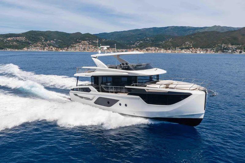 The Image of 2026 Absolute Navetta 58 yacht cruising on open sea near scenic coastline. - 2
