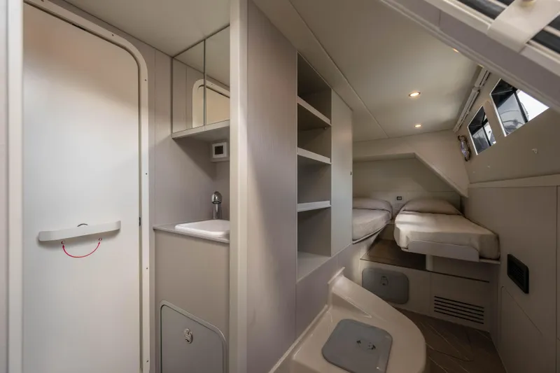Slide: The Image of Interior of 2026 Absolute Navetta 58 yacht cabin with twin beds and compact bathroom. - 58