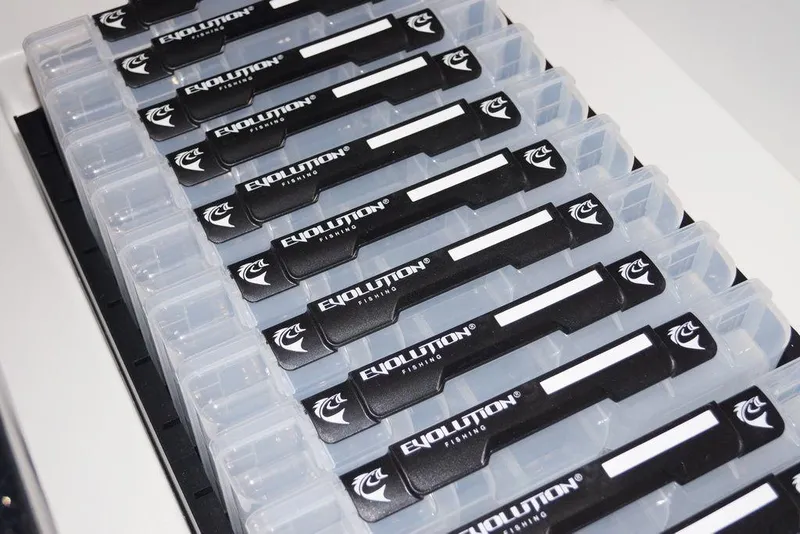 Slide: The Image of Fishing tackle boxes labeled "Evolution" neatly organized in a Skeeter ZXE20, 2020 model. - 20