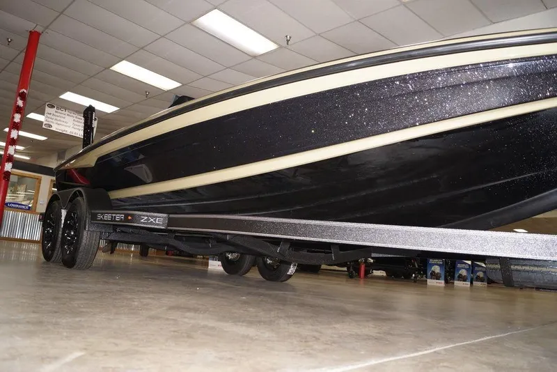 Slide: The Image of 2020 Skeeter ZXE20 boat on display in showroom, showcasing sleek design and trailer. - 22