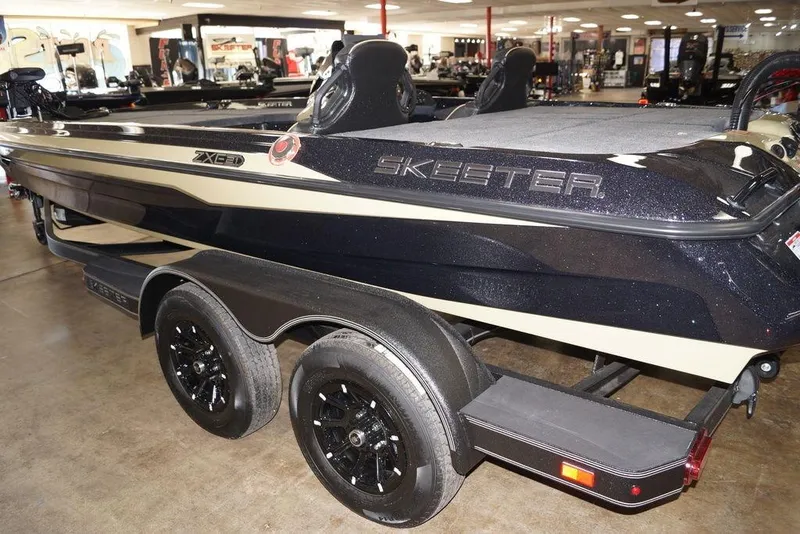 Slide: The Image of 2020 Skeeter ZXE20 boat in showroom, featuring sleek design and dual-axle trailer. - 3