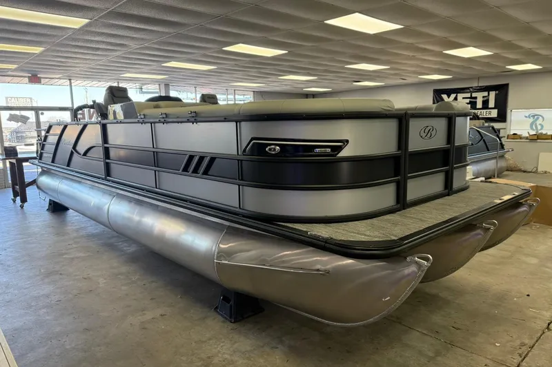 Slide: The Image of 2026 Bentley Pontoons Elite 253 Swingback in showroom, showcasing sleek design and modern features. - 2