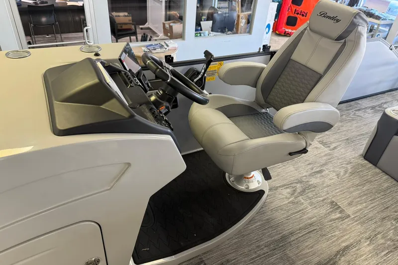 Slide: The Image of 2026 Bentley Pontoons Elite 253 Swingback helm with luxurious captain's chair and modern controls. - 4