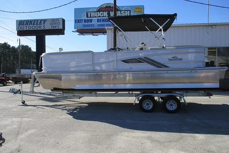 The Image of 2026 SunCatcher Fusion 324RC pontoon boat on trailer at outdoor dealership. - 1