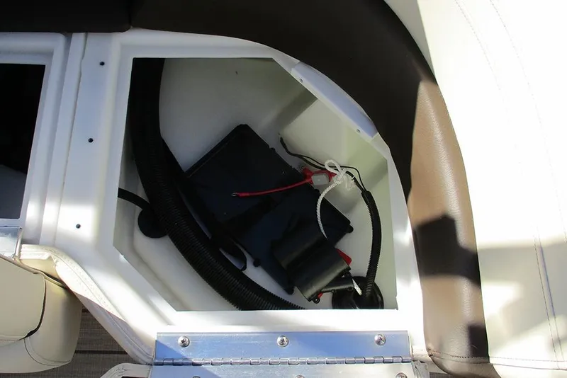 Slide: The Image of 2026 SunCatcher Fusion 324RC boat storage compartment with wiring and components. - 27