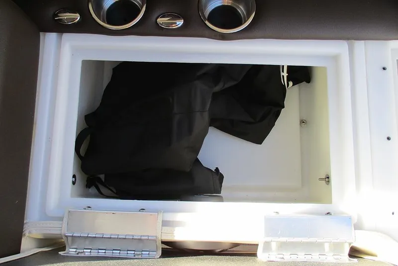 Slide: The Image of Open storage compartment in 2026 SunCatcher Fusion 324RC boat, containing a black bag. - 28