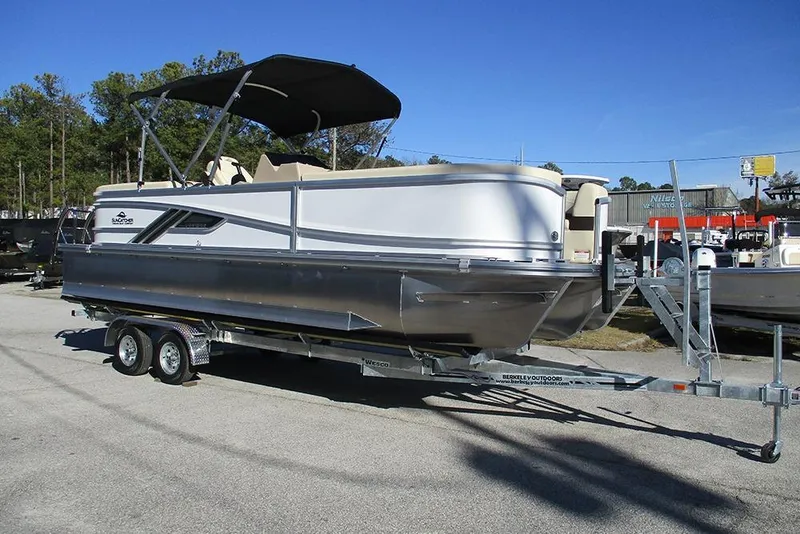 Slide: The Image of 2026 SunCatcher Fusion 324RC pontoon boat on trailer, parked outdoors under clear sky. - 5