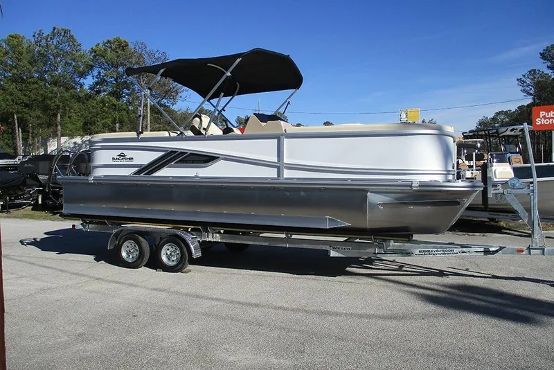 Slide: The Image of 2026 SunCatcher Fusion 324RC pontoon boat on trailer, parked outdoors. - 6