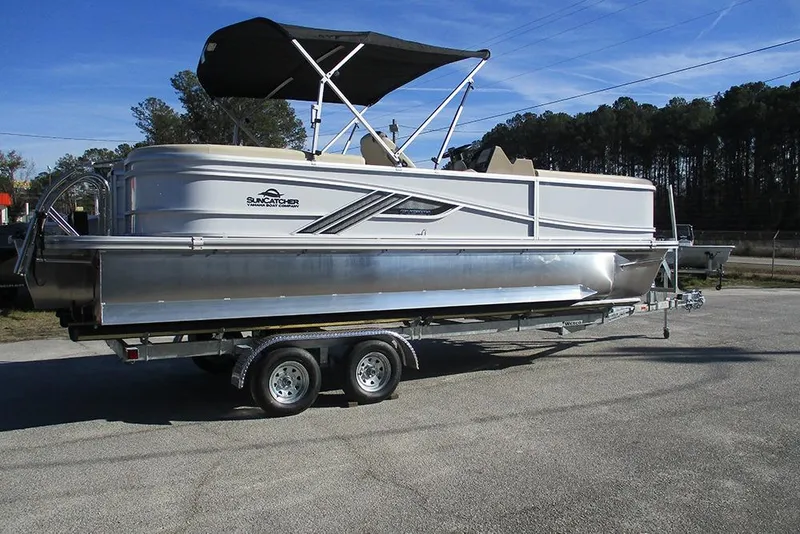 Slide: The Image of 2026 SunCatcher Fusion 324RC pontoon boat on trailer, parked outdoors. - 7