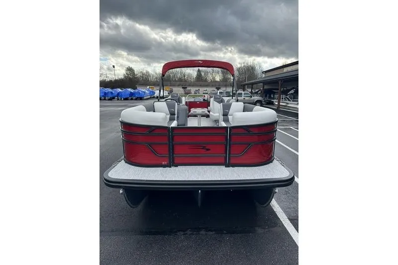 Slide: The Image of 2026 Bennington 20 S Quad Bench pontoon boat with red accents in a parking lot. - 3