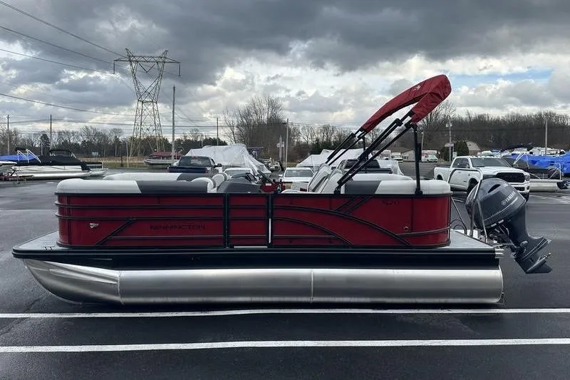 Slide: The Image of 2026 Bennington 20 S Quad Bench pontoon boat with red canopy in parking lot. - 9