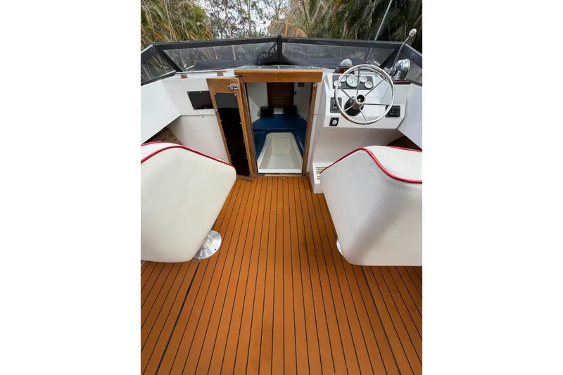 Slide: The Image of 1967 Formula 233 boat interior with wooden deck and white seating. - 10