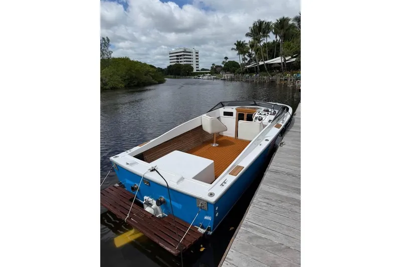 Slide: The Image of 1967 Formula 233 boat docked on a calm river with lush greenery. - 2