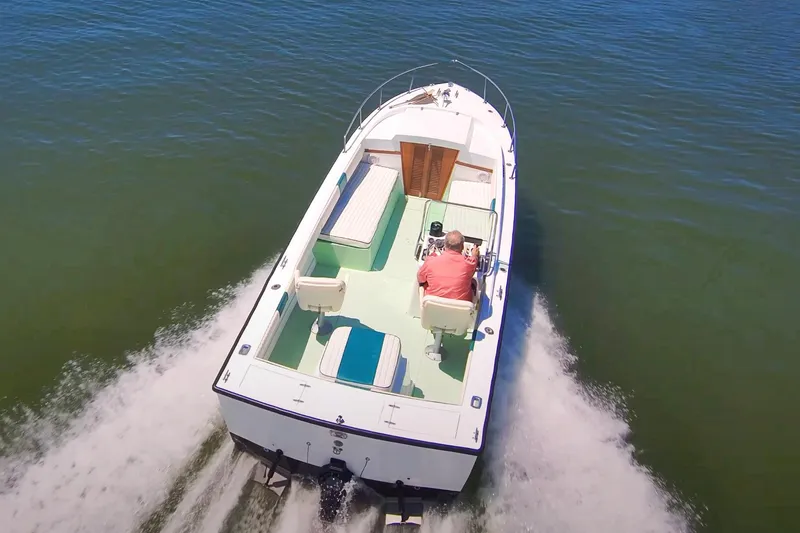The Image of 1976 Aquasport 24 Launch boat cruising on open water, aerial view. - 0