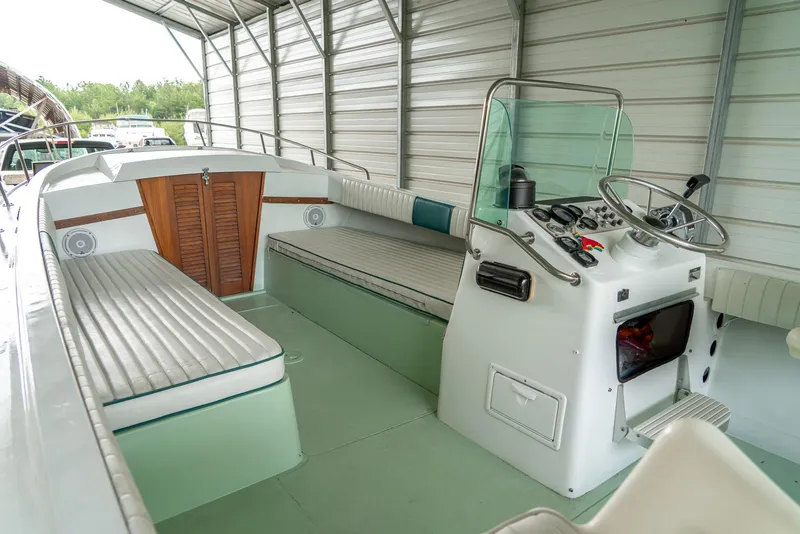 Slide: The Image of 1976 Aquasport 24 Launch boat interior with seating and steering console in a covered area. - 15