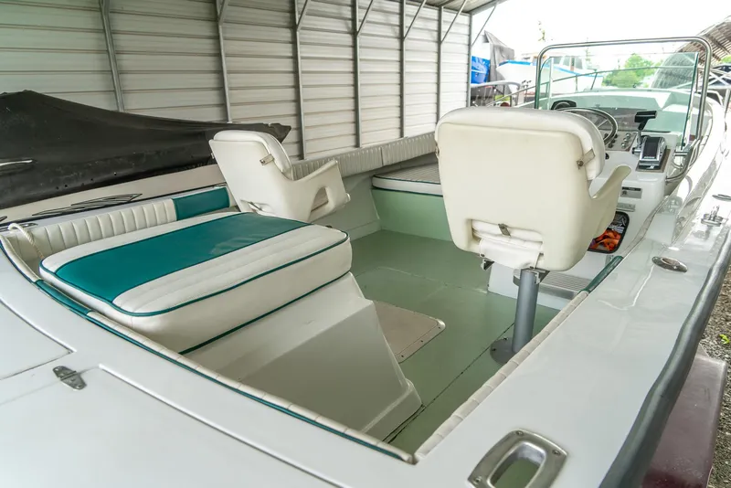 Slide: The Image of 1976 Aquasport 24 Launch boat interior with white and teal seating under a metal canopy. - 19