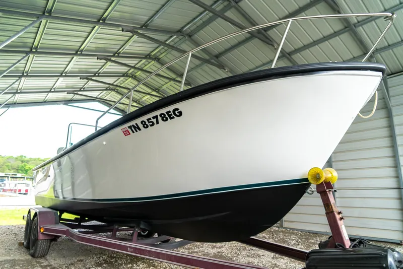 Slide: The Image of 1976 Aquasport 24 Launch boat on trailer under metal shelter. - 6