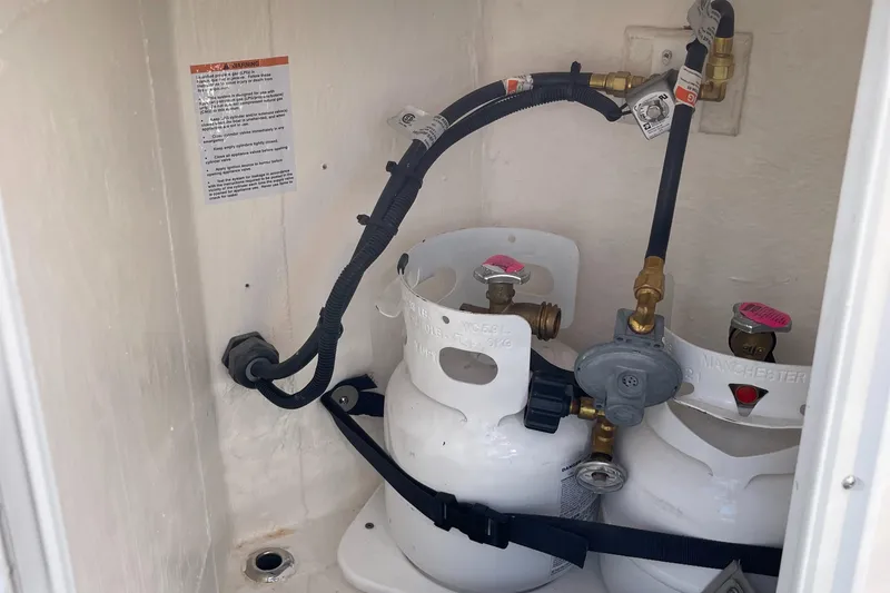 Slide: The Image of 2023 Cutwater C-288 propane tank storage compartment with dual tanks and safety straps. - 24