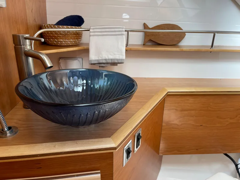 Slide: The Image of 2023 Cutwater C-288 bathroom with modern glass vessel sink and wooden accents. - 48