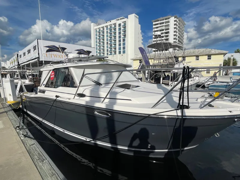 Slide: The Image of 2023 Cutwater C-288 boat docked at a marina with buildings in the background. - 7