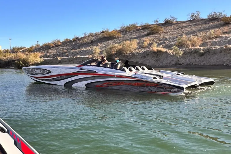 Slide: The Image of High-performance 2009 Skater 388 speedboat on a calm river, featuring sleek design and vibrant graphics. - 2