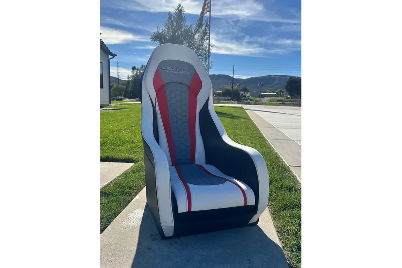 Slide: The Image of High-back Skater 388 seat, 2009 model, with red and gray accents, outdoors on a sunny day. - 24