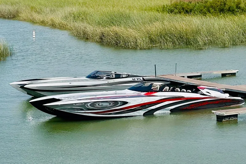 Slide: The Image of Two sleek Skater boats docked on a calm lake, showcasing vibrant designs. - 5