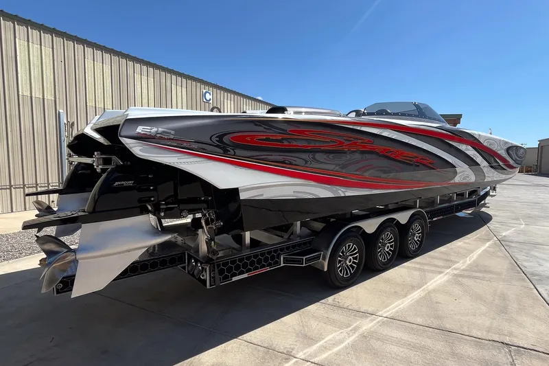 Slide: The Image of 2009 Skater 388 powerboat with sleek design, red and black accents, on a multi-axle trailer. - 6