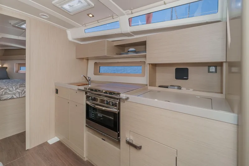 Slide: The Image of Modern kitchen interior of 2025 Beneteau Oceanis 37.1 yacht, featuring sleek cabinetry and appliances. - 12