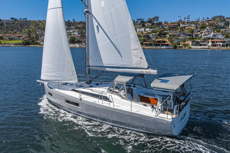 Slide: The Image of 2025 Beneteau Oceanis 37.1 sailing on a serene lake with scenic background. - 36