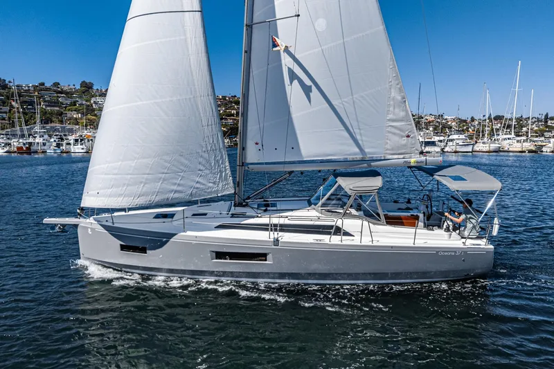 Slide: The Image of 2025 Beneteau Oceanis 37.1 sailboat cruising on a sunny day in a marina. - 37