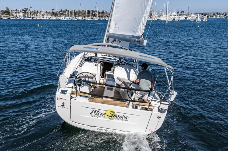 Slide: The Image of 2025 Beneteau Oceanis 37.1 sailing in a marina, rear view with sails up. - 43