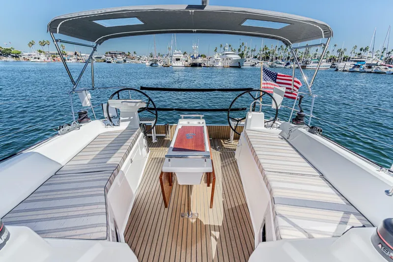 Slide: The Image of 2025 Beneteau Oceanis 37.1 yacht cockpit with dual steering wheels and American flag. - 62