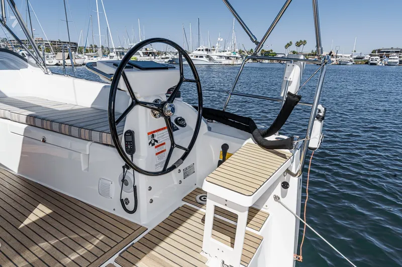Slide: The Image of 2025 Beneteau Oceanis 37.1 sailboat cockpit with steering wheel, docked in marina. - 67