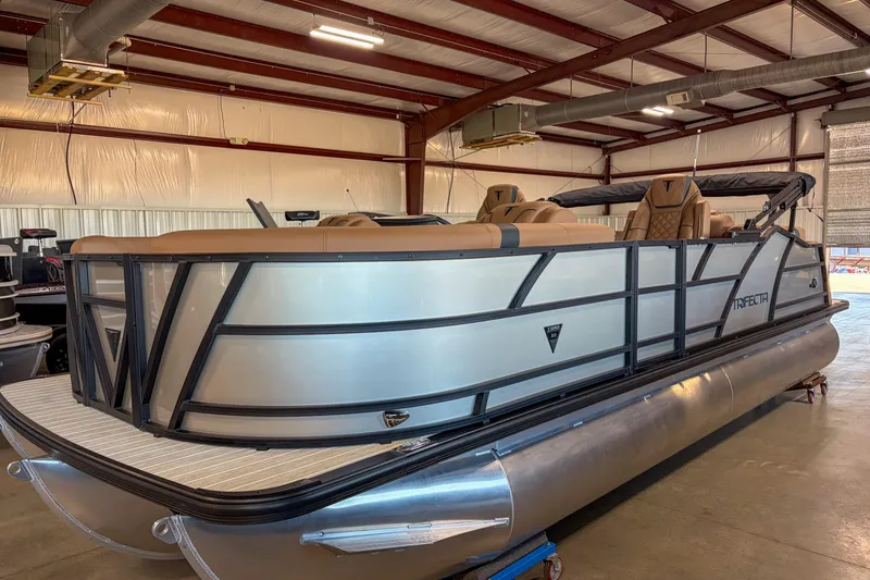 The Image of 2026 Trifecta 23 RF SS pontoon boat in a warehouse, showcasing sleek design and luxury seating. - 1