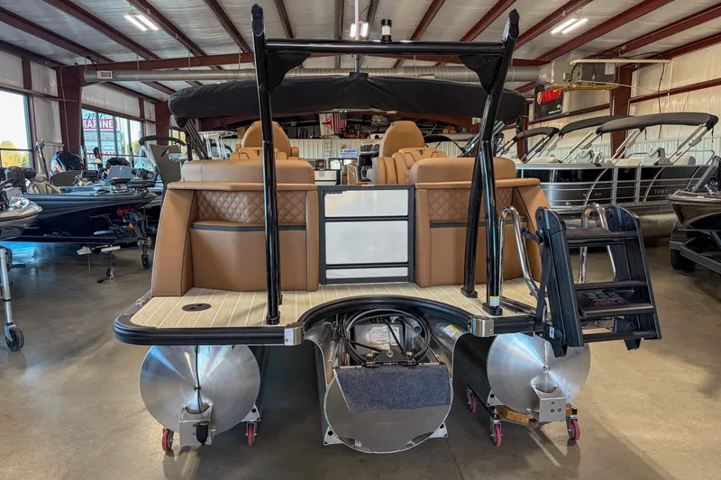 Slide: The Image of 2026 Trifecta 23 RF SS pontoon boat in showroom, rear view with seating and ladder. - 17